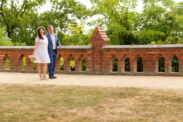 Hochzeit Tangermünde | Brautpaar steht an einer Mauer im Schlosspark
